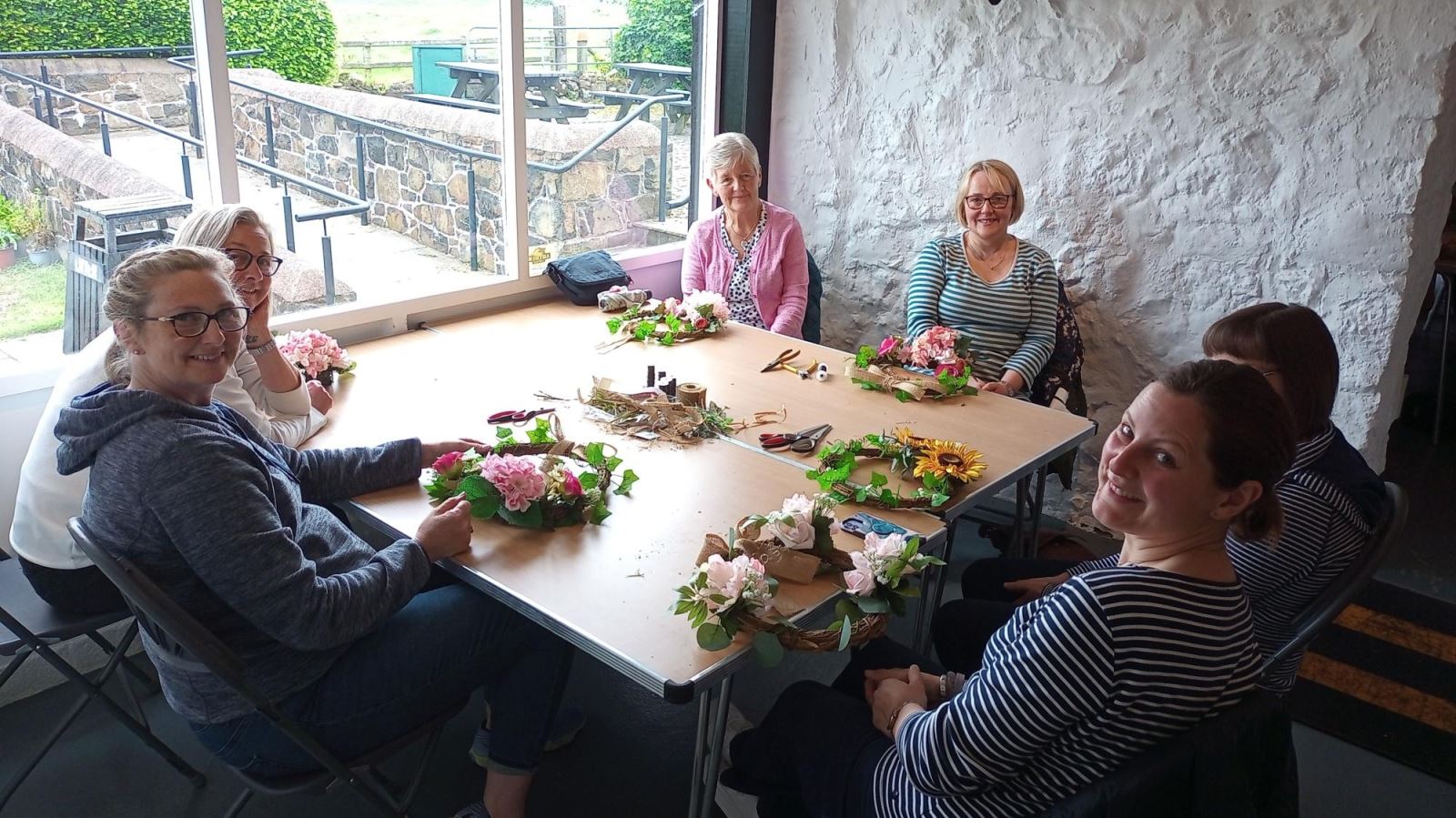 Group of ladies sitting round a table making wreaths